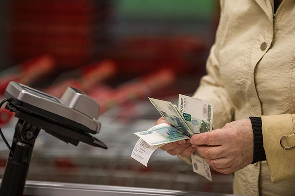 Женщина расплачивается в продуктовом магазине