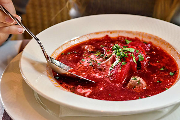 Женщина ест борщ